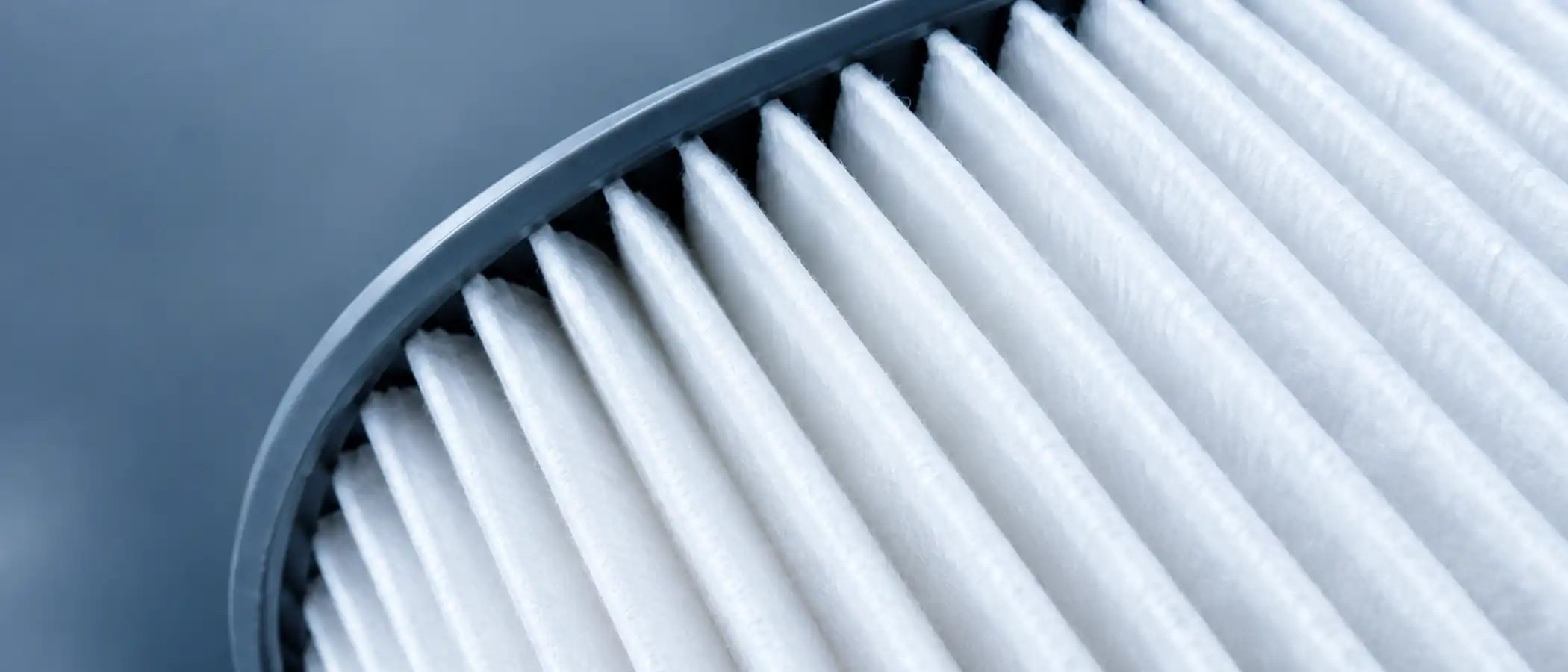 Macro-opname van een wit geplooid filterelement met de vouwen scherp in beeld