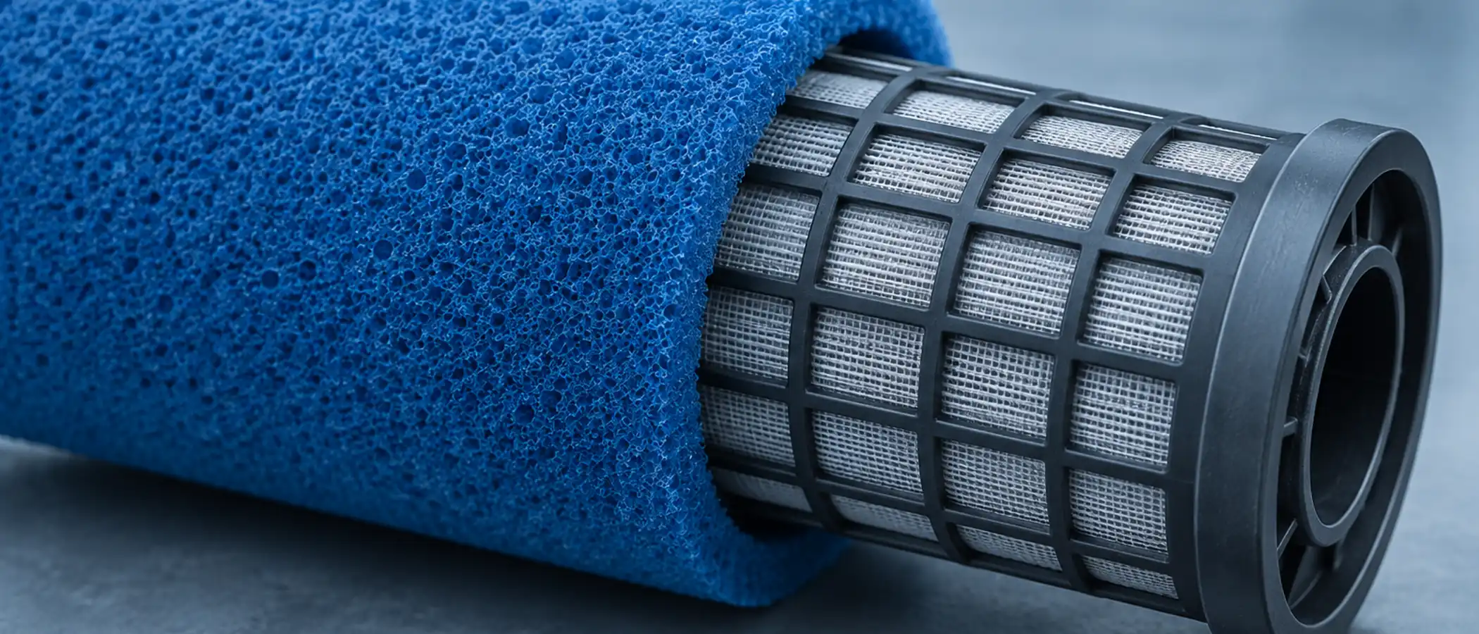 Blauw schuimrubberen filterhoes half over een filterkorf geschoven, poreuze structuur zichtbaar